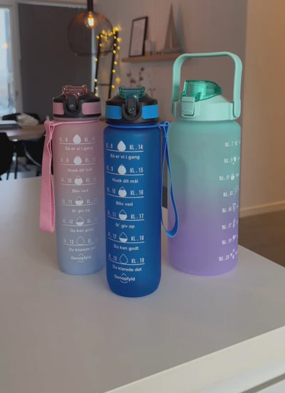 2L motivationsvandflaske med tidspåmindelser. Smart vandflaske til voksne. Drikkeflaske med sugerør og one-click åbning. BPA-fri og 100 % tæt. Opvaskemaskinesikker drikkedunk. Vandflaske til arbejde, bil, fitness og hverdagsbrug. Hjælp til at drikke mere vand. Flaske med mål og tidsmarkering. Sund livsstil. Bedre hydrering. Populær drikkeflaske til kvinder og mænd. Smart Makro flaske. Stor vandflaske med motiverende design. dansk tekst.