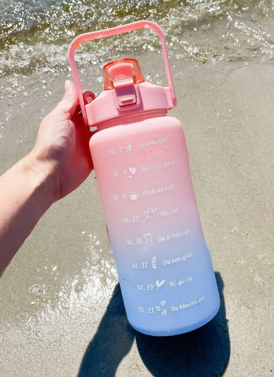 2L motivationsvandflaske med tidspåmindelser. Smart vandflaske til voksne. Drikkeflaske med sugerør og one-click åbning. BPA-fri og 100 % tæt. Opvaskemaskinesikker drikkedunk. Vandflaske til arbejde, bil, fitness og hverdagsbrug. Hjælp til at drikke mere vand. Flaske med mål og tidsmarkering. Sund livsstil. Bedre hydrering. Populær drikkeflaske til kvinder og mænd. Smart Makro flaske. Stor vandflaske med motiverende design. dansk tekst.